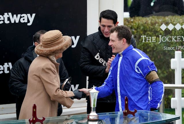 Le jockey Paul Townend serre la main de la reine consort alors qu'elle présente le trophée après la victoire d'Energumene dans la Betway Queen Mother Champion Chase (Tim Goode/PA)