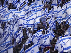 Des Israéliens manifestent contre le plan de refonte judiciaire du Premier ministre Benjamin Netanyahu devant le parlement à Jérusalem, le lundi 27 mars 2023.