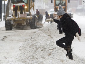 Un piéton se fraye un chemin sur un banc de neige laissé derrière lui alors que les niveleuses déblayaient la neige à Edmonton.  Les résidents de certaines villes de la région de Toronto se sont fâchés contre les grands bancs de neige et les allées bloquées causées par les chasse-neige.