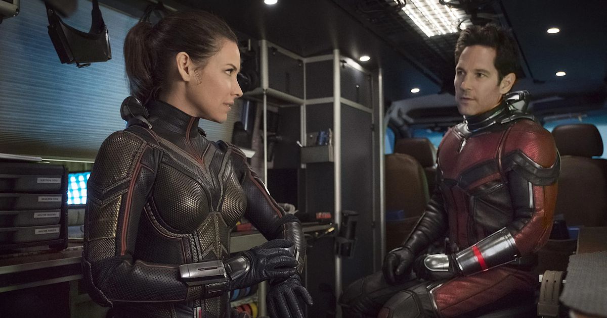 Wasp (Evangeline Lilly) et Ant-Man (Paul Rudd) sont assis en costumes de super-héros complets avec leurs masques à l'arrière d'un camion dans une scène un peu sombre et générique d'Ant-Man and the Wasp de 2018