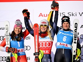 Mikaela Shiffrin, des États-Unis, célèbre sa victoire en slalom féminin avec Wendy Holdener, deuxième de la Suisse, et Anna Swenn Larsson, de la Suède, troisième, lors de la Coupe du monde de ski alpin FIS à Are, en Suède, le 11 mars 2023.