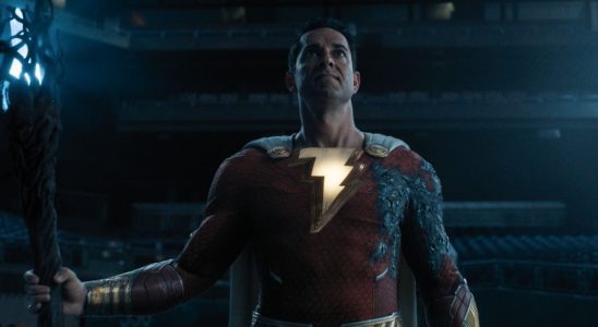 Zachary Levi stands in a baseball stadium holding a powerful staff in Shazam! Fury of the Gods.