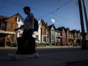 Une personne passe devant une rangée de maisons à Toronto