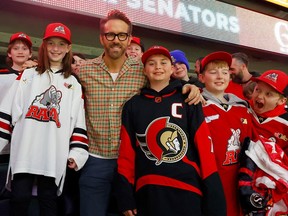 Les joueurs de hockey mineur ont une séance de photos avec l'acteur Ryan Reynolds lors du match des Sénateurs contre les Flyers jeudi soir.