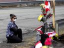 La travailleuse de soins et première intervenante Alicia Cunningham s'agenouille devant un mémorial improvisé pour la const.  Heidi Stevenson, décédée lors de la tuerie de dimanche en Nouvelle-Écosse.