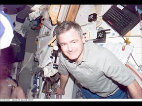 L'astronaute Marc Garneau, spécialiste de mission représentant l'Agence spatiale canadienne (ASC), pose pour une photo à bord du pont intermédiaire de la navette spatiale Endeavour en orbite autour de la Terre.  La scène a été enregistrée avec une caméra fixe électronique (ESC).