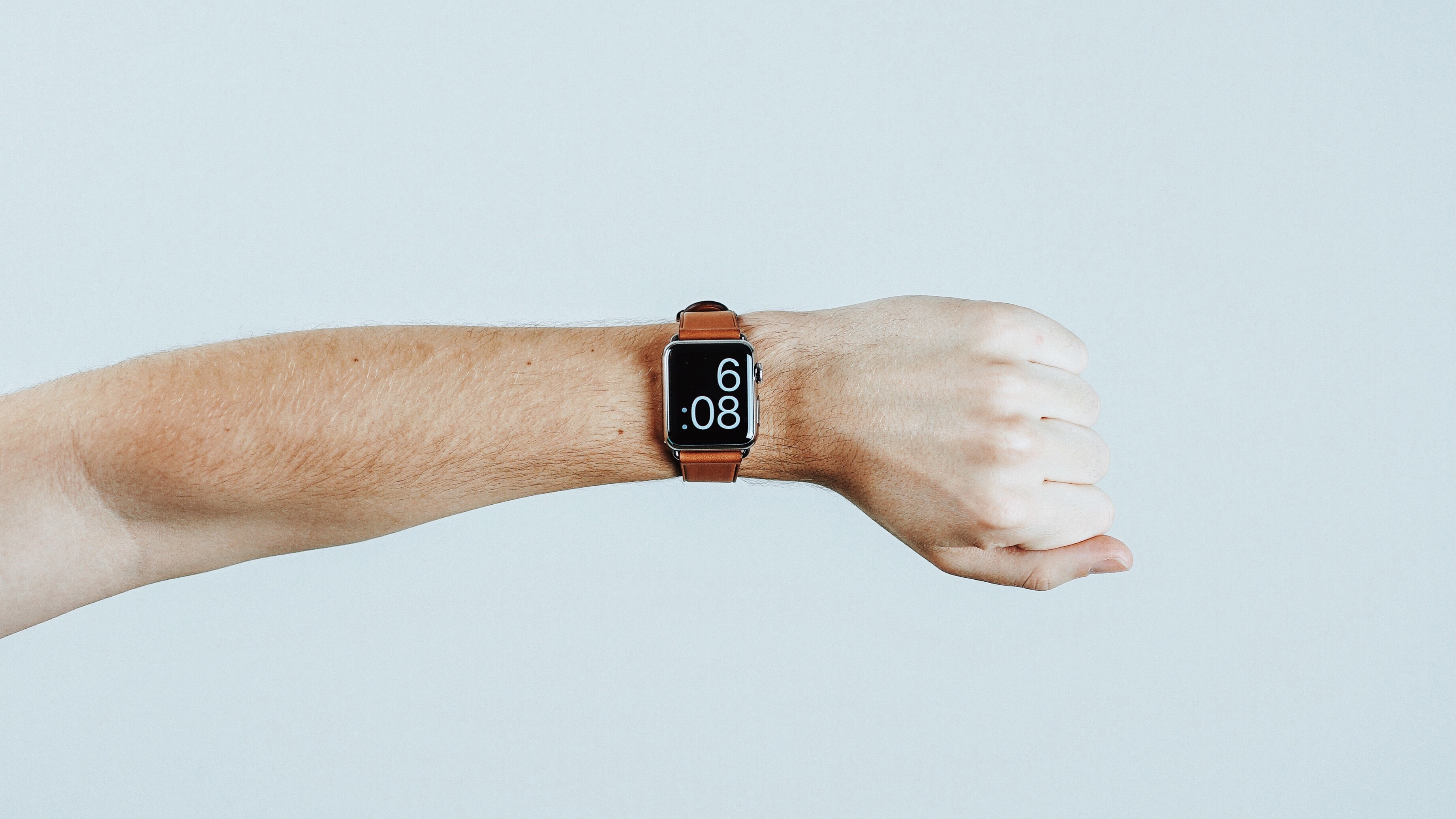 le bras de quelqu'un avec une montre connectée au poignet indiquant l'heure