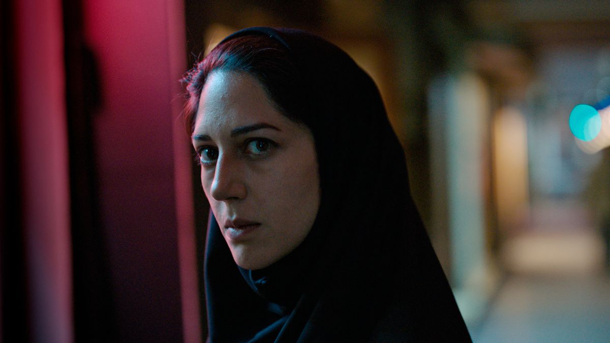 Une femme (Zar Amir Ebrahimi) portant un foulard et debout dans une ruelle sombre la nuit.