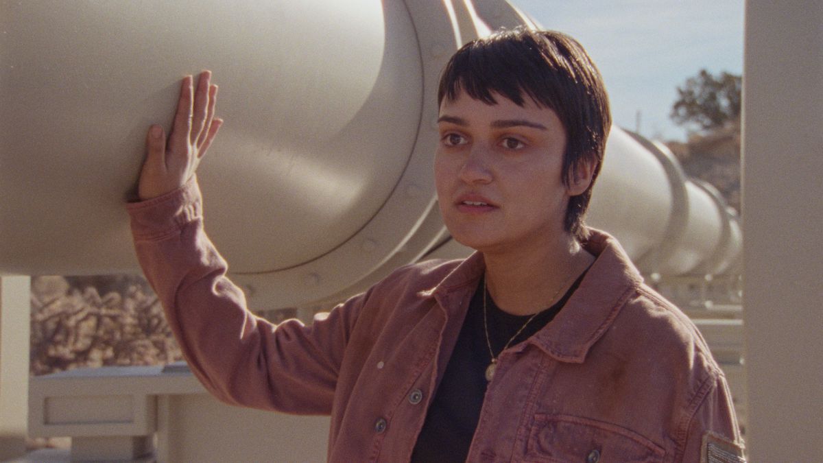 Xochi (Ariela Barer) passe sa main le long d'un oléoduc dans How to Blow Up a Pipeline