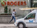 Un piéton passe devant l'édifice Rogers à Toronto.