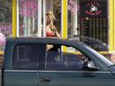 Le 2 février 2010, une barista d'un stand d'expresso Grab-N-Go Bikini Hut détient de l'argent alors qu'elle salue un client, juste à l'extérieur des limites de la ville d'Everett, Washington.