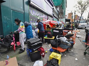 Le personnel de la ville de Vancouver enlève les structures de fortune et les tentes appartenant aux personnes vivant dans un campement le long de la rue East Hastings dans le Downtown Eastside, à Vancouver, en Colombie-Britannique, le 5 avril 2023.
