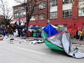 Le personnel de la ville de Vancouver enlève les structures de fortune et les tentes appartenant aux personnes vivant dans un campement le long de la rue East Hastings dans le Downtown Eastside, à Vancouver, en Colombie-Britannique, le 5 avril 2023.