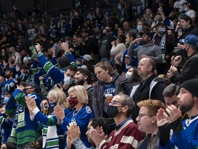 Les fans des Canucks applaudissent après un but de l'équipe locale lors du match d'ouverture à domicile des Canucks de Vancouver 2021-22.