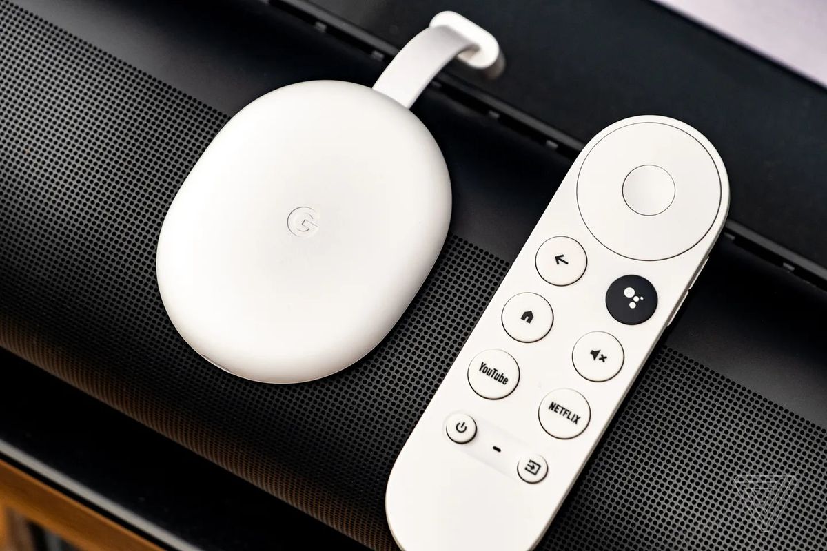 Le Google Chromecast avec Google TV en blanc, posé sur une barre de son.