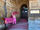 Une militante pour le climat d'On2Ottawa a jeté un seau de peinture rose sur l'entrée du bureau du premier ministre à Ottawa avant de s'enchaîner seins nus à la porte du bureau le 18 avril 2023. 