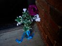 Des fleurs se trouvent devant la porte d'entrée du complexe d'appartements Baywood, 11445 132 St., le lundi 20 mars 2023, à la suite de la mort par balle du const.  Travis Jordan et Const.  Brett Ryan jeudi dernier.  