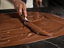 Le tempérage est essentiel pour assurer l'éclat et le claquant du chocolat.  Une équipe de scientifiques de l'alimentation dirigée par le Dr Alejandro Marangoni a trouvé un raccourci vers la technique de mise en table illustrée ici qui contourne également les unités de tempérage utilisées dans la fabrication à grande échelle. 