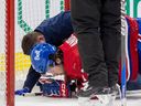 Josh Anderson des Canadiens de Montréal est soigné par le thérapeute sportif en chef Graham Rynbend après avoir été abattu par Mikhail Sergachev du Lightning de Tampa Bay lors de la troisième période du match de la Ligue nationale de hockey à Montréal le mardi 21 mars 2023.