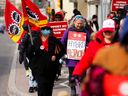 Des travailleurs et sympathisants de l'AFPC manifestent devant le bureau de la présidente du Conseil du Trésor, Mona Fortier, à Ottawa, le 21 avril.