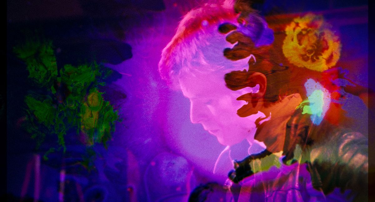 Le visage d'un jeune David Bowie apparaît à travers des éclaboussures tourbillonnantes de violet et d'orange dans Moonage Daydream
