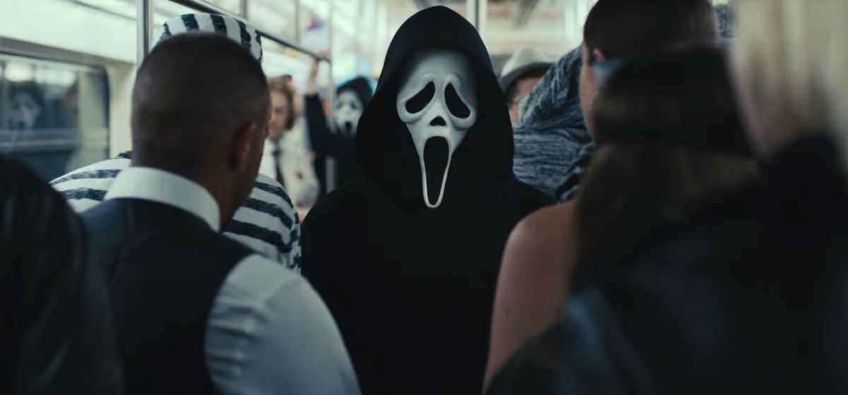 Une personne portant un masque Ghostface se tient sur une voiture de métro bondée de New York dans une image de Scream VI.