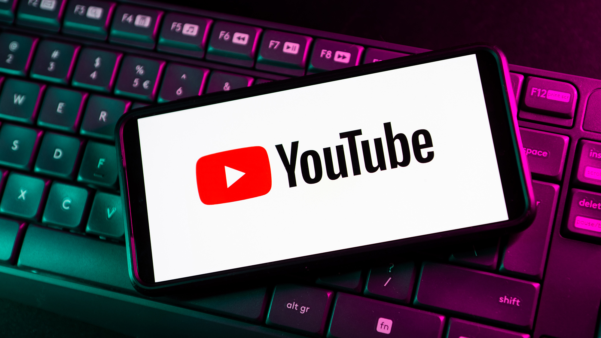 Le logo YouTube apparaît sur un téléphone au-dessus d'un clavier