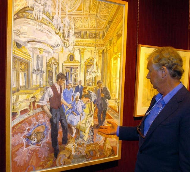 L'artiste John Wonnacott fait des gestes vers son portrait de groupe de la famille royale commandé par la Portrait Gallery for the Millennium à Agnew&# x002019;s gallery à Mayfair, Londres, en 2005 (Michael Stephens/PA)