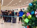 Les passagers attendent de s'enregistrer auprès de WestJet à l'aéroport international de Calgary (YYC), car le froid extrême à Calgary et les conditions hivernales dans d'autres régions du Canada ont causé de nombreux retards et annulations de vols le jeudi 22 décembre 2022. Azin Ghaffari/Postmedia