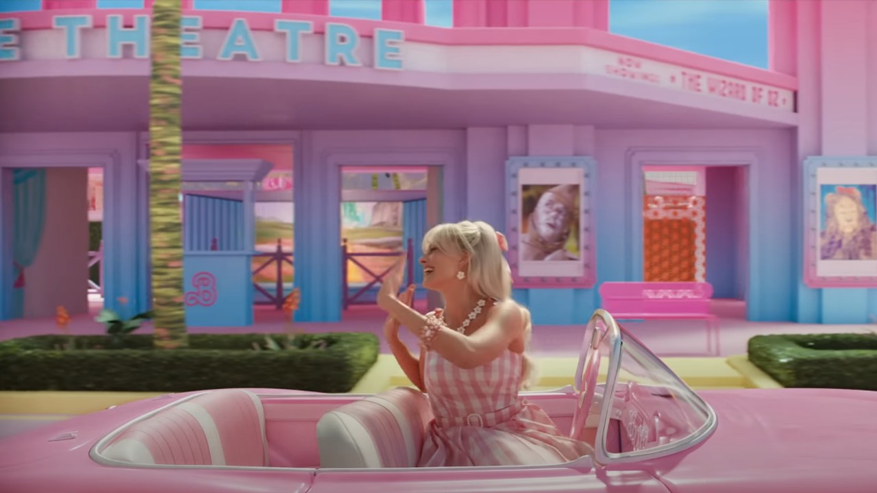 Barbie assise dans sa voiture agitant la remorque Barbie