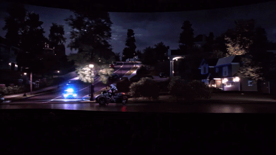 GIF : Bourne saute sur une moto et accélère, poursuivi par une voiture de police (mais tout se passe sur une scène visible) 