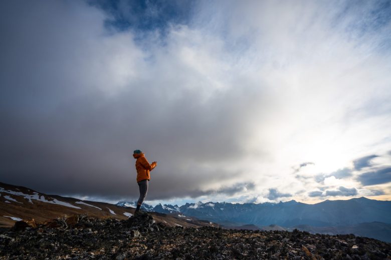 Kris Tompkins lève les yeux vers le ciel avec la chaîne de montagnes de Patagonie en toile de fond. (Jimmy Chin)