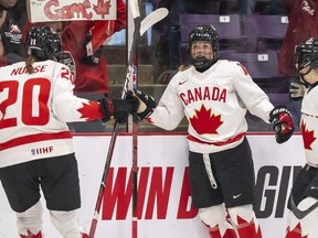 L'attaquante canadienne Sarah Fillier (10) est félicitée par ses coéquipières l'attaquante Sarah Nurse (20) et la défenseure Renata Fast (14) après avoir marqué contre la Suisse lors de la deuxième période de la demi-finale du Championnat mondial de hockey féminin de l'IIHF à Brampton, en Ontario, samedi avril 15, 2023.