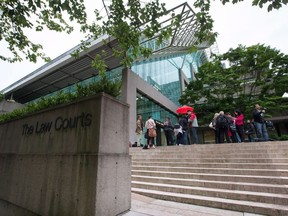 Les médias attendent devant la Cour suprême de la Colombie-Britannique à Vancouver, en Colombie-Britannique, le mardi 2 juin 2015. Un procès a appris qu'une jeune fille de 13 ans de Burnaby, en Colombie-Britannique, traversait un parc de quartier lorsqu'elle a été traînée dans la forêt par Ibrahim Ali, agressé sexuellement et étranglé.