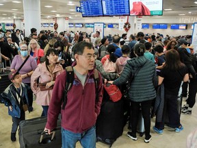 Les passagers des compagnies aériennes Sunwing font la queue pour l'enregistrement à l'aéroport international de Cancun après l'annulation de nombreux vols vers le Canada en raison des conditions météorologiques hivernales rigoureuses, le 27 décembre 2022.