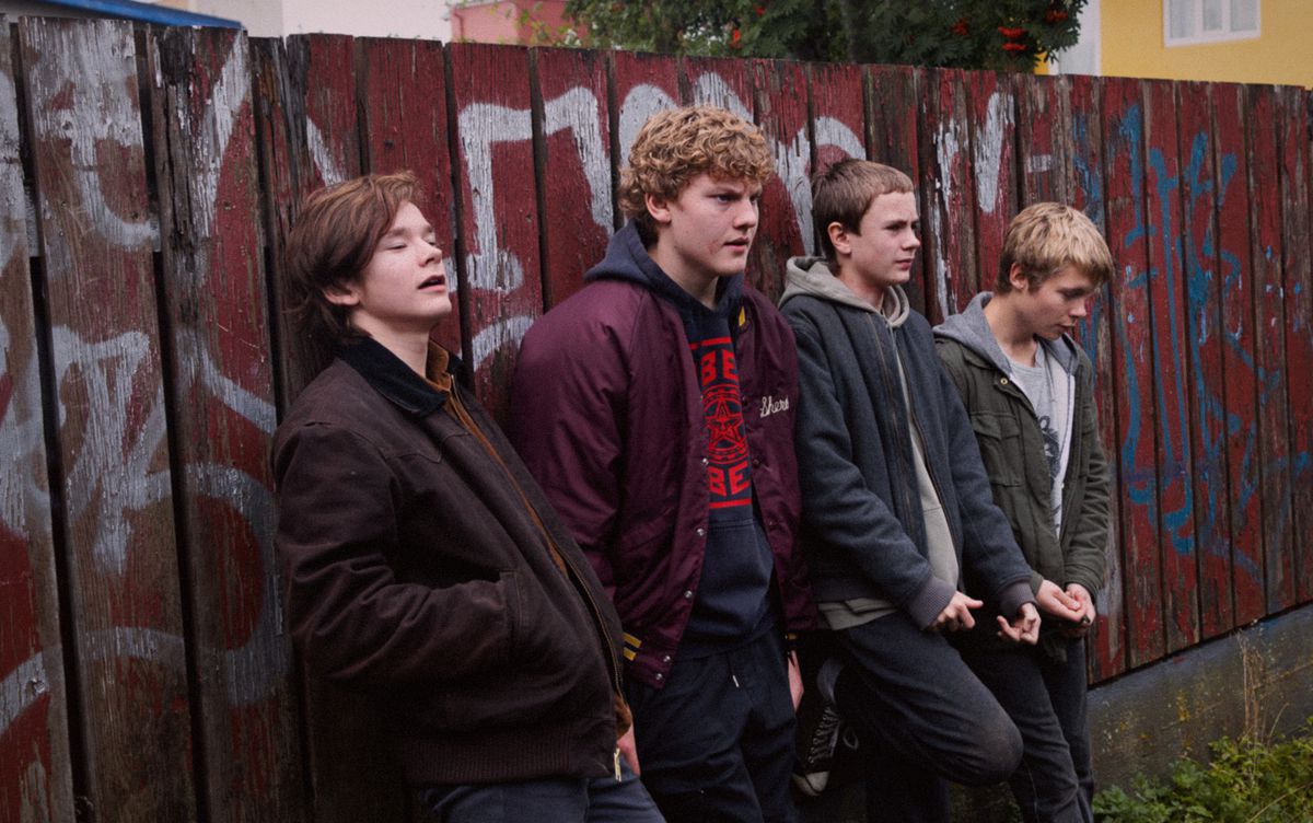 Un groupe de jeunes garçons nordiques s'appuie contre un mur tagué dans Beautiful Beings.