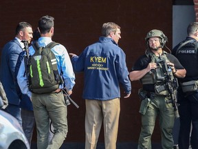 Le gouverneur du Kentucky, Andy Beshear, s'entretient avec la police déployée sur les lieux d'une fusillade de masse près du stade de baseball Slugger Field au centre-ville de Louisville, Kentucky, États-Unis, le 10 avril 2023.