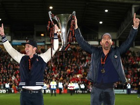 Rob McElhenney et Ryan Reynolds célèbrent avec le trophée de la Ligue nationale Vanarama alors que Wrexham est promu au football anglais le 22 avril 2023 à Wrexham, au Pays de Galles.