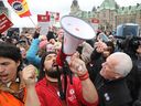 Le président de l'AFPC, Chris Aylward, à droite, et des membres de l'AFPC en grève lors d'un rassemblement sur la colline du Parlement à Ottawa, le 26 avril.
