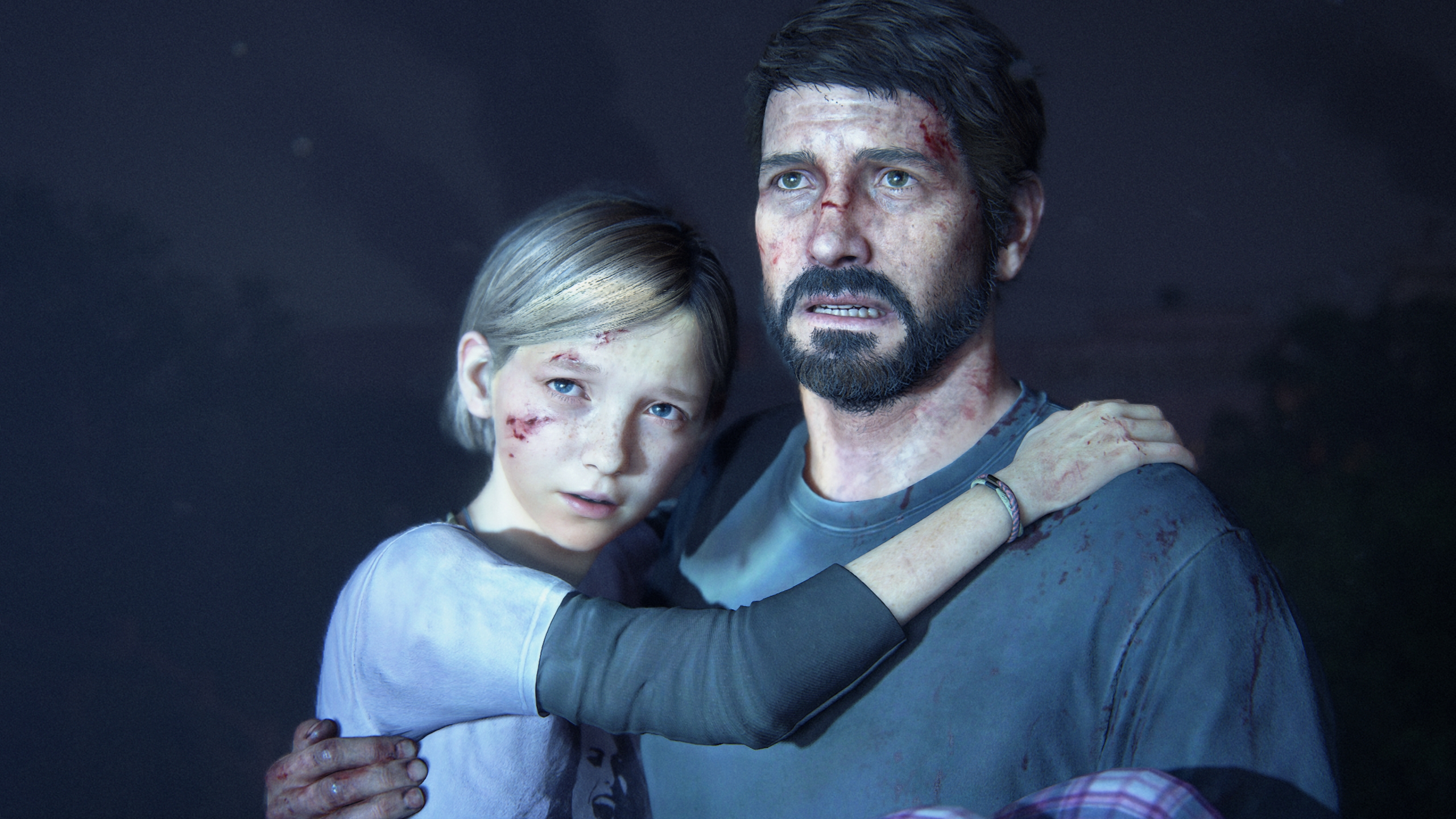Un homme tient sa fille dans ses bras tandis qu'un projecteur est braqué sur eux