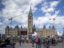 Un petit groupe manifeste sur la rue Wellington à Ottawa devant les portes de la Colline du Parlement, le 2 juillet 2022. La compétence du gouvernement fédéral prend actuellement fin dès que quelqu'un quitte la Colline du Parlement et s'engage sur la rue Wellington.