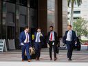Les piétons marchent à l'extérieur du palais de justice du comté de Palm Beach à West Palm Beach, en Floride.  Les entreprises de Wall Street se développent dans le sud de la Floride.