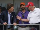 L'ancien président américain Donald Trump, à droite, s'entretient avec Donald Trump Jr., au centre, et Tucker Carlson au 16e tee lors de la dernière ronde du tournoi de golf Bedminster Invitational LIV à Bedminster, NJ, le 31 juillet 2022. 