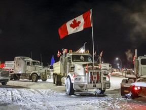 Les manifestants du mandat du vaccin anti-COVID-19 se rassemblent alors qu'un convoi de camions bloque l'autoroute au passage frontalier américain très fréquenté à Coutts, en Alberta, le mardi 1er février 2022.