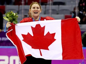 Hayley Wickenheiser célèbre avec un drapeau après que l'équipe canadienne a battu l'équipe américaine 3-2 en prolongation pour remporter la médaille d'or au hockey féminin aux Jeux olympiques d'hiver de 2014 à Sotchi, en Russie.
