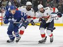 Aaron Ekblad des Panthers de la Floride et son coéquipier Anthony Duclair patinent contre Matthew Knies des Maple Leafs de Toronto lors du premier match de la deuxième ronde des séries éliminatoires de la Coupe Stanley 2023 à la Scotiabank Arena le 2 mai 2023 à Toronto, Canada.