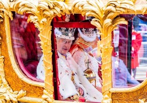Le roi Charles et la reine Camilla regardent le défilé du couronnement se diriger vers le palais de Buckingham à Londres, le 6 mai 2023.