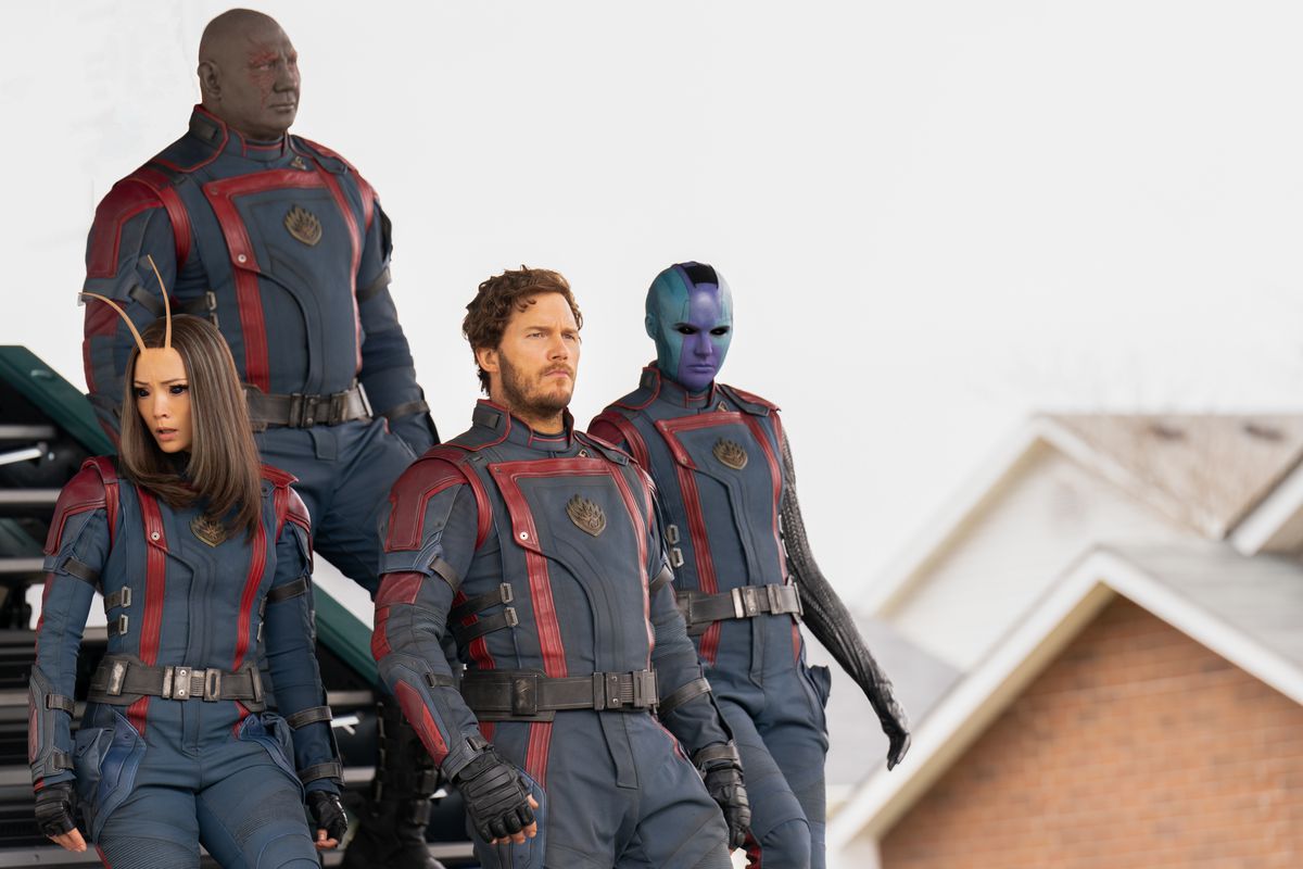 Les Gardiens de la Galaxie dans leurs uniformes Nova descendent les escaliers d'un vaisseau spatial dans un quartier de banlieue dans Les Gardiens de la Galaxie Vol.  3