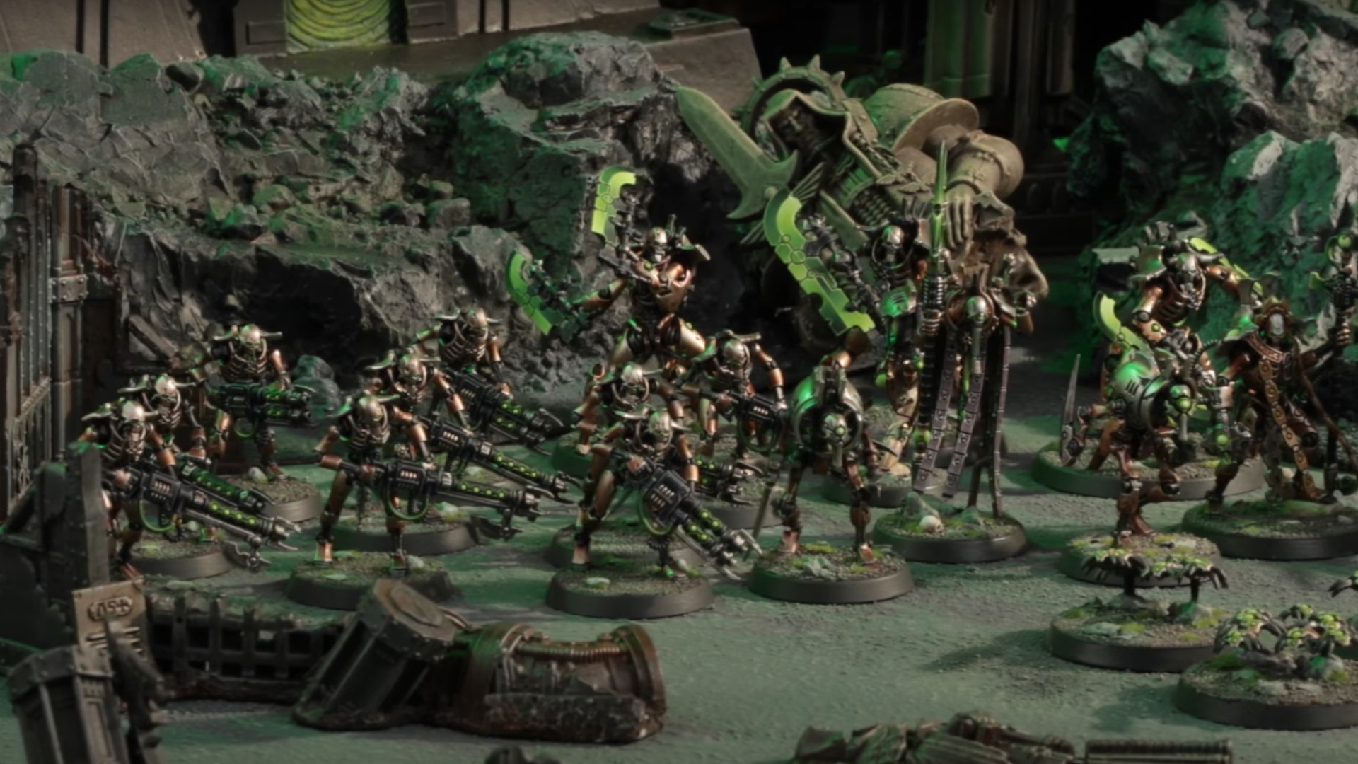 Une armée de miniatures métalliques Necron en mouvement à travers un paysage désolé et en ruine
