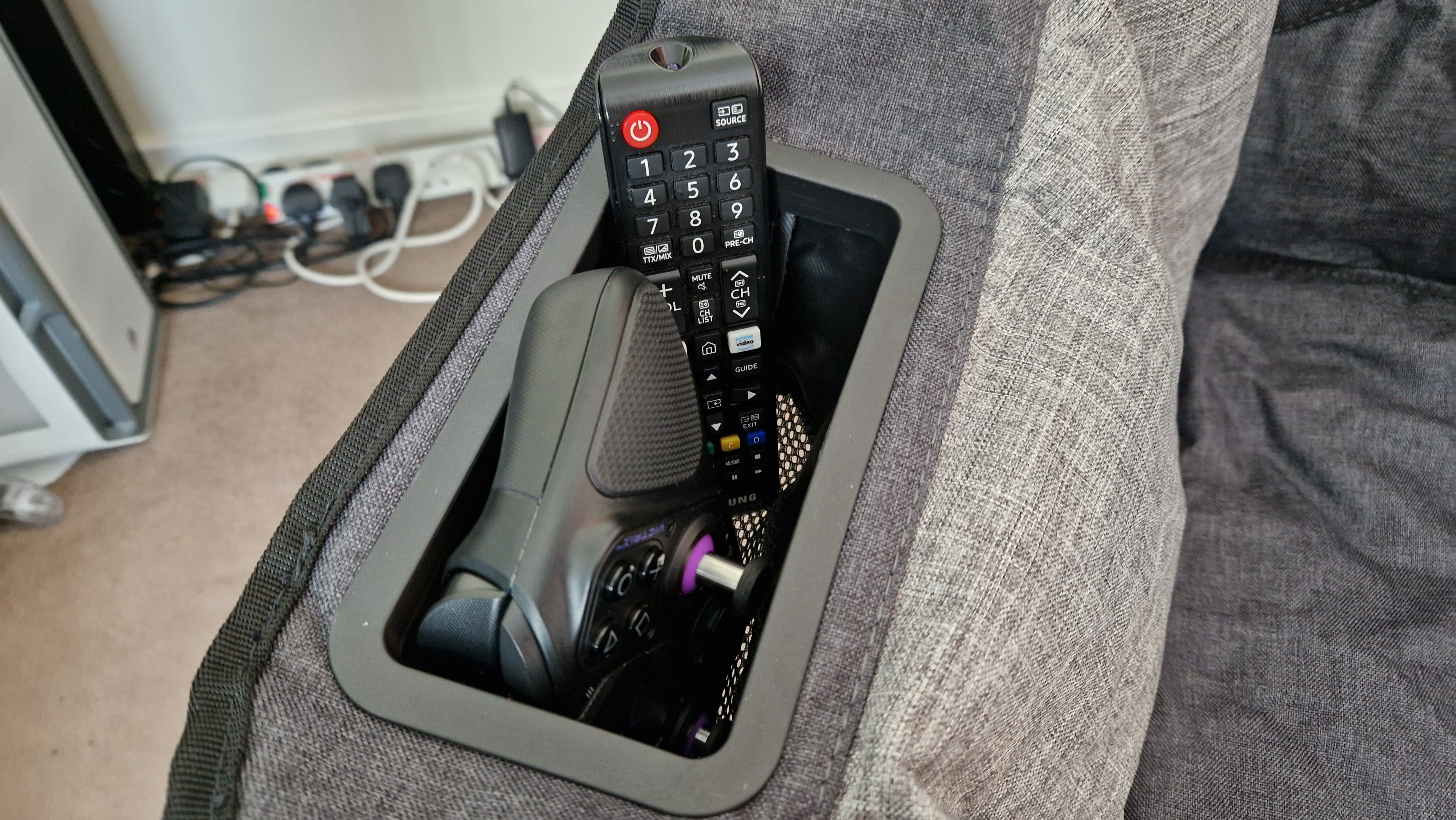 La poche de la chaise de jeu pliable transportant un contrôleur Victrix Pro BFG PS5 et une télécommande Samsung TV